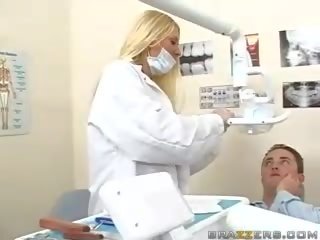 Vacker tonårs bystiga blondin tandläkare visar henne klantskallar till en patienten