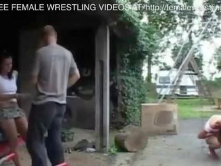 Two girls fight in a car junkyard